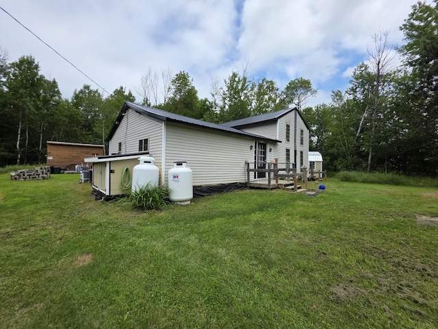 17 Cross St, Kingman Twp, ME 04451 - view of side of home featuring a yard, a wooden deck, and a metal roof