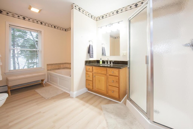 106 Sunset Bay Dr, Steuben, ME 04680 - bathroom with wood finished floors, vanity, a stall shower, a bath, and a baseboard heating unit