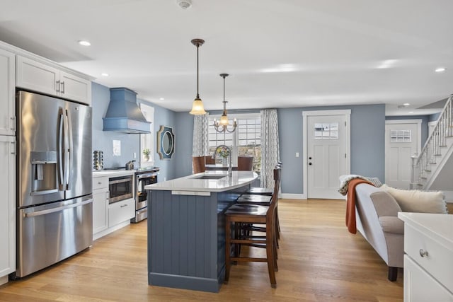 38 Atlantic Ave, Boothbay Harbor, ME 04538 - kitchen featuring stainless steel appliances, custom exhaust hood, light wood-style flooring, a breakfast bar, and recessed lighting