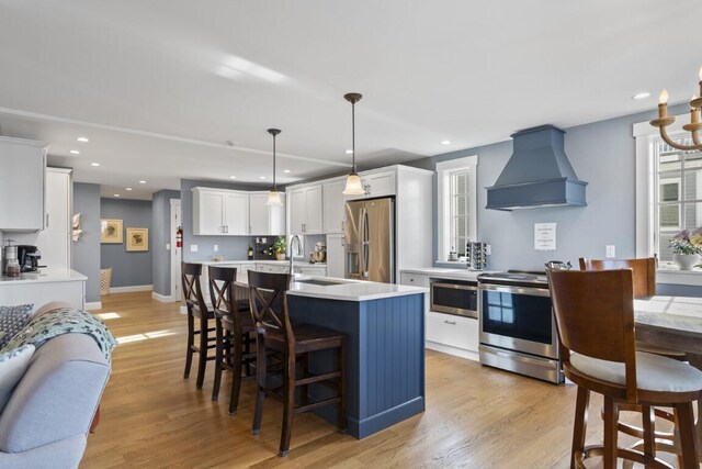 38 Atlantic Ave, Boothbay Harbor, ME 04538 - kitchen with premium range hood, appliances with stainless steel finishes, light countertops, white cabinets, and a kitchen bar