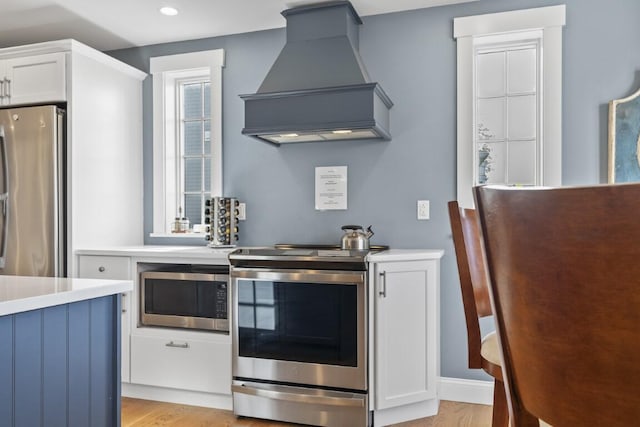 38 Atlantic Ave, Boothbay Harbor, ME 04538 - kitchen featuring custom range hood, appliances with stainless steel finishes, light countertops, white cabinetry, and recessed lighting