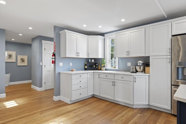 38 Atlantic Ave, Boothbay Harbor, ME 04538 - kitchen with stainless steel fridge with ice dispenser, light countertops, light wood-style flooring, white cabinets, and recessed lighting