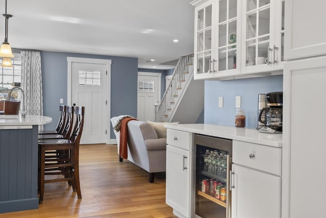38 Atlantic Ave, Boothbay Harbor, ME 04538 - dining space featuring wine cooler, a dry bar, light wood-style flooring, recessed lighting, and stairs