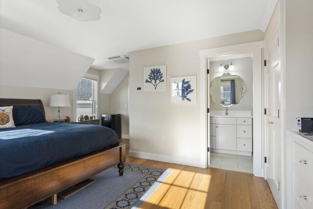 38 Atlantic Ave, Boothbay Harbor, ME 04538 - bedroom featuring light wood-style floors, ensuite bath, and vaulted ceiling