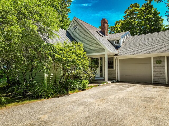 3 Curtis Ave, Camden, ME 04843 - view of front facade with asphalt driveway, a chimney, a garage, and roof with shingles