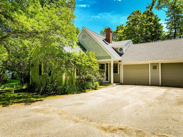 3 Curtis Ave, Camden, ME 04843 - view of front of property featuring an attached garage, a chimney, a shingled roof, and asphalt driveway