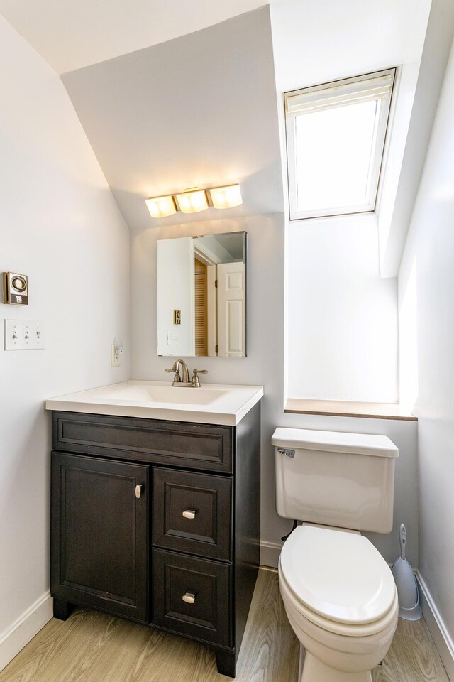 3 Curtis Ave, Camden, ME 04843 - half bathroom featuring vanity, wood finished floors, and lofted ceiling