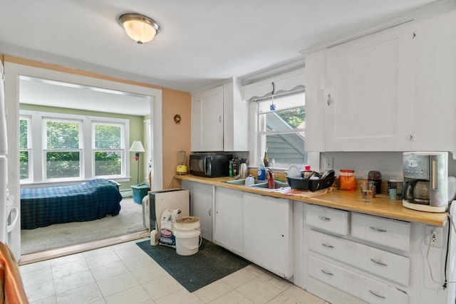 47 Fall Brook St, Portland, ME 04103 - kitchen with black microwave, light countertops, and white cabinetry