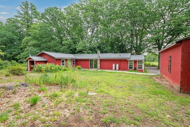 219 Mouse Ln, Alfred, ME 04002 - back of property featuring a lawn, a metal roof, and a chimney
