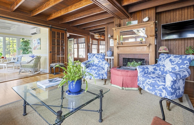 78 Seashore Ave, Portland, ME 04108 - living area featuring a wall mounted air conditioner, plenty of natural light, wooden walls, a fireplace, and a wood ceiling with exposed beams