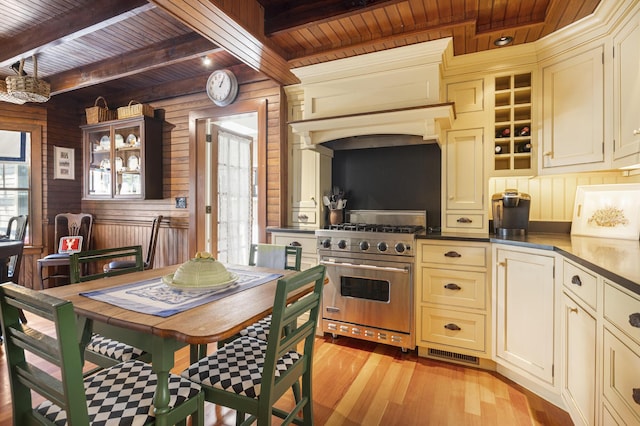 78 Seashore Ave, Portland, ME 04108 - kitchen featuring designer stove, a wood ceiling with exposed beams, cream cabinets, wooden walls, and light wood finished floors