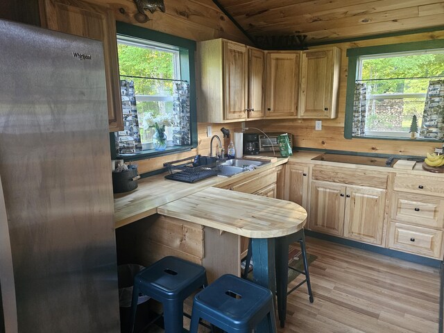 210 Cobb Rd, Lee, ME 04455 - kitchen featuring light wood-style flooring, vaulted ceiling, healthy amount of natural light, a breakfast bar area, and light brown cabinetry