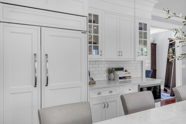 10 Paddock Way, Falmouth, ME 04105 - kitchen with built in appliances, white cabinets, tasteful backsplash, light stone countertops, and ornamental molding