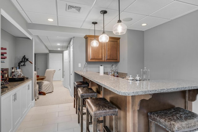 10 Paddock Way, Falmouth, ME 04105 - kitchen featuring a breakfast bar, a peninsula, recessed lighting, brown cabinetry, and pendant lighting