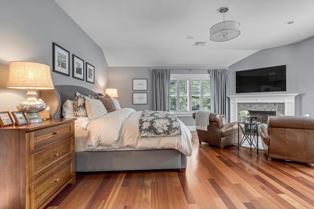 10 Paddock Way, Falmouth, ME 04105 - bedroom with vaulted ceiling, wood finished floors, and a fireplace