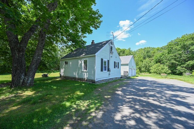 488 Bog Rd, Hermon, ME 04401 - view of side of property featuring a chimney, an outbuilding, a yard, a garage, and a shingled roof