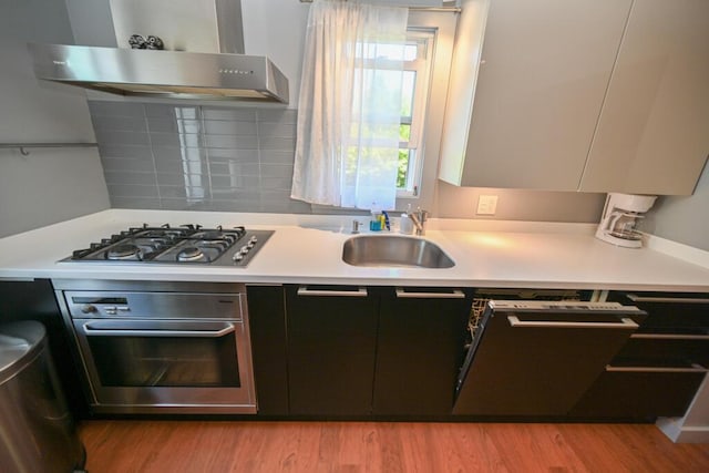 488 Bog Rd, Hermon, ME 04401 - kitchen featuring stainless steel appliances, wall chimney range hood, light countertops, light wood-style flooring, and modern cabinets