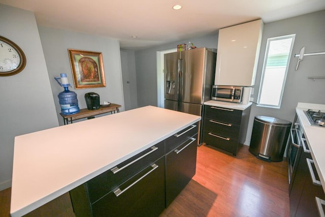 488 Bog Rd, Hermon, ME 04401 - kitchen with stainless steel appliances, a kitchen island, light wood-style flooring, light countertops, and dark cabinets