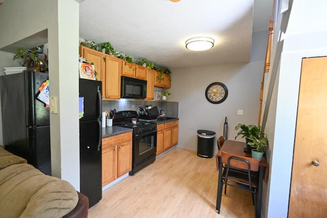 488 Bog Rd, Hermon, ME 04401 - kitchen with black appliances, dark countertops, light wood-style flooring, and decorative backsplash