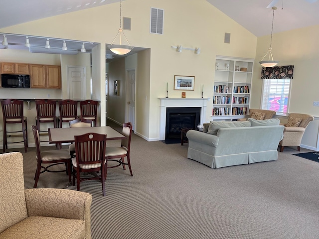 23 Chestnut Ln Unit 23, Wells, ME 04090 - carpeted dining area featuring high vaulted ceiling and a fireplace with flush hearth