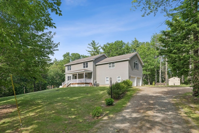7 Dakota Ln, Dresden, ME 04342 - view of front of home with covered porch, a garage, a storage unit, a front lawn, and driveway