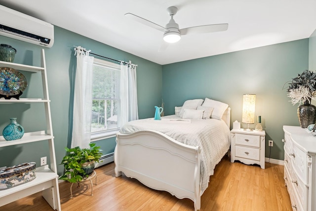 7 Dakota Ln, Dresden, ME 04342 - bedroom with a wall mounted air conditioner, a baseboard heating unit, light wood-style flooring, and a ceiling fan