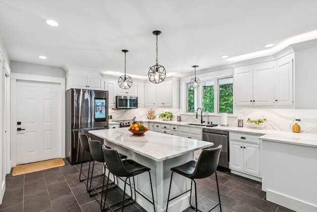 7 Dakota Ln, Dresden, ME 04342 - kitchen with stainless steel appliances, a breakfast bar, white cabinetry, recessed lighting, and decorative backsplash