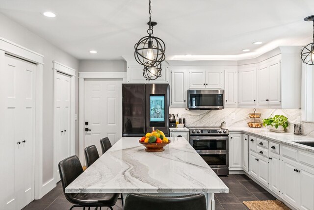 7 Dakota Ln, Dresden, ME 04342 - kitchen with appliances with stainless steel finishes, recessed lighting, white cabinets, tasteful backsplash, and light stone countertops