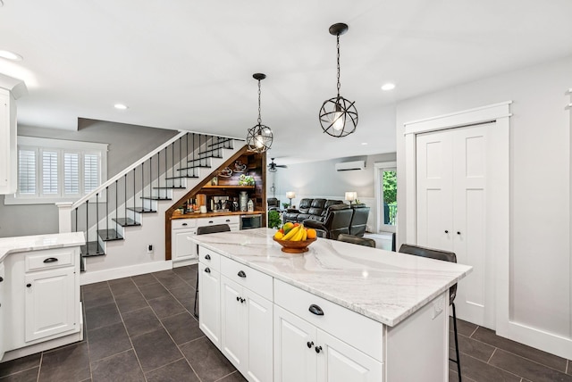 7 Dakota Ln, Dresden, ME 04342 - kitchen featuring a wall mounted air conditioner, recessed lighting, light stone counters, white cabinets, and hanging light fixtures
