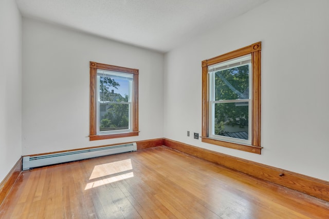15 Snow Park, Bath, ME 04530 - unfurnished room with a baseboard radiator, healthy amount of natural light, and wood-type flooring