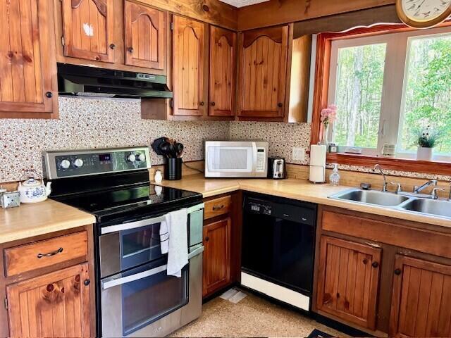 2 Oak Ridge Rd, Kennebunkport, ME 04046 - kitchen featuring range with two ovens, under cabinet range hood, white microwave, black dishwasher, and brown cabinets