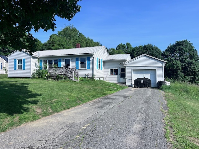 17 Pleasant St, Wilton, ME 04294 - view of front facade with a chimney, a metal roof, a front yard, asphalt driveway, and a garage