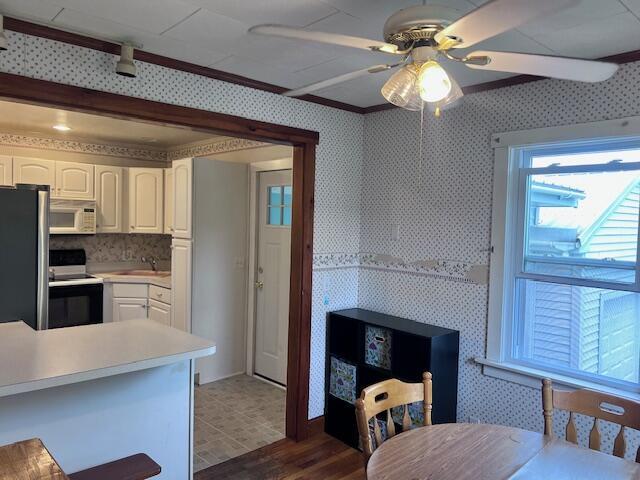 17 Pleasant St, Wilton, ME 04294 - kitchen featuring electric stove, white microwave, freestanding refrigerator, white cabinetry, and ornamental molding
