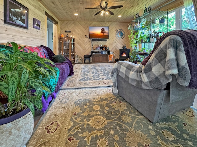 749 Main St, Madawaska, ME 04756 - living area with wood walls, a wood stove, wooden ceiling, and ceiling fan
