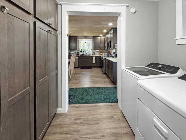 749 Main St, Madawaska, ME 04756 - laundry room featuring cabinet space, washer and clothes dryer, and light wood-type flooring