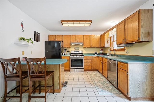 100 Starlight Dr, Brewer, ME 04412 - kitchen with stainless steel appliances, under cabinet range hood, a breakfast bar, a peninsula, and light tile patterned floors