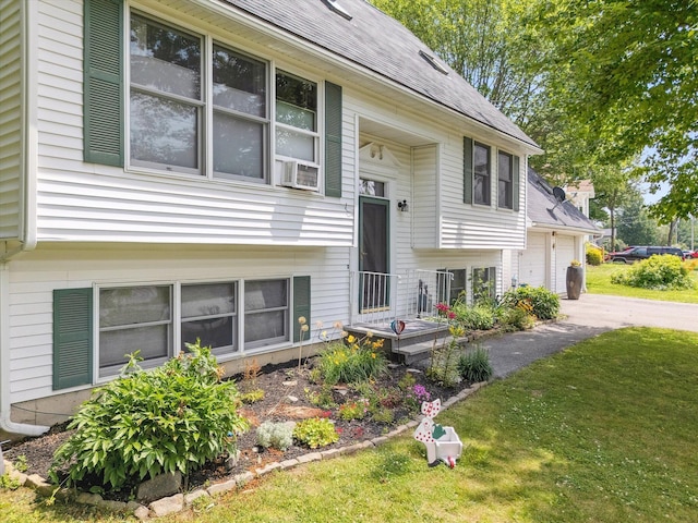 100 Starlight Dr, Brewer, ME 04412 - split foyer home featuring asphalt driveway, a front lawn, a shingled roof, cooling unit, and a garage