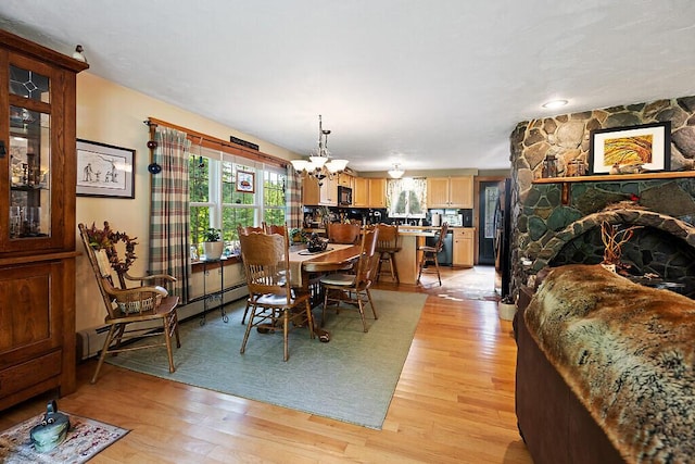 1 Castle View Ln, Belgrade, ME 04917 - dining space featuring a chandelier, light wood-type flooring, and a baseboard radiator