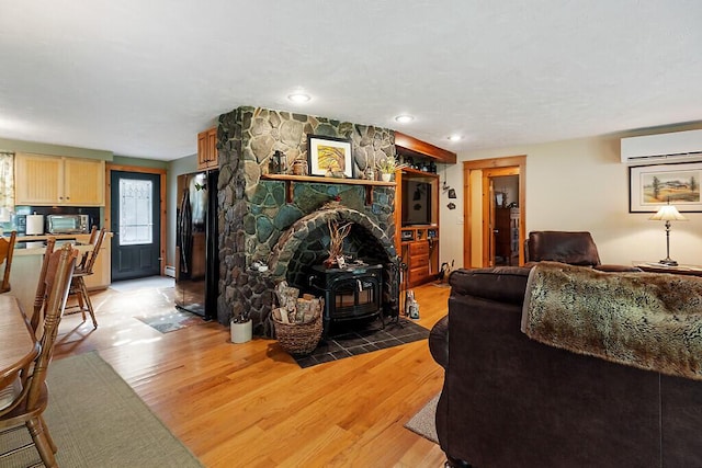 1 Castle View Ln, Belgrade, ME 04917 - living area with an AC wall unit, a wood stove, light wood finished floors, and recessed lighting
