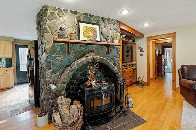 1 Castle View Ln, Belgrade, ME 04917 - detailed view of a wood stove, wood finished floors, stainless steel microwave, and freestanding refrigerator