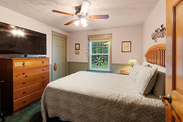 1 Castle View Ln, Belgrade, ME 04917 - carpeted bedroom with a textured ceiling, a wainscoted wall, and ceiling fan