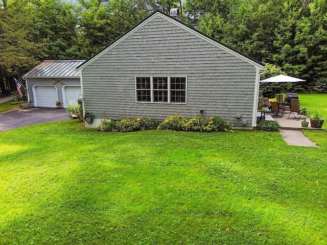1 Castle View Ln, Belgrade, ME 04917 - view of home's exterior featuring a yard, a chimney, a garage, and a standing seam roof