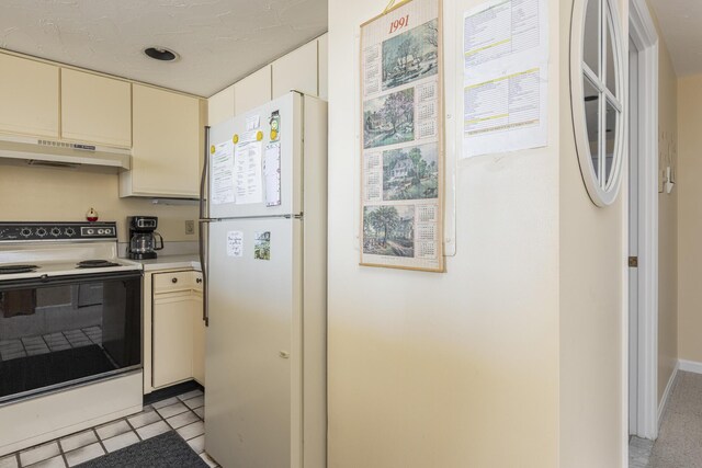 191 E Grand Ave Unit 504, Old Orchard Beach, ME 04064 - kitchen featuring freestanding refrigerator, range with electric stovetop, under cabinet range hood, cream cabinetry, and light countertops