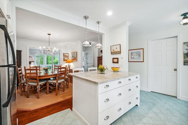 239 Sea Rd Unit 32, Kennebunk, ME 04043 - kitchen with crown molding, freestanding refrigerator, white cabinetry, light stone counters, and a chandelier