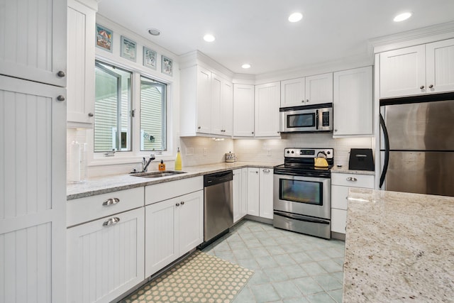 239 Sea Rd Unit 32, Kennebunk, ME 04043 - kitchen with stainless steel appliances, backsplash, white cabinetry, light stone counters, and recessed lighting