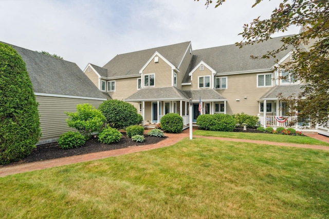 239 Sea Rd Unit 32, Kennebunk, ME 04043 - view of front of house with a front yard, covered porch, and roof with shingles