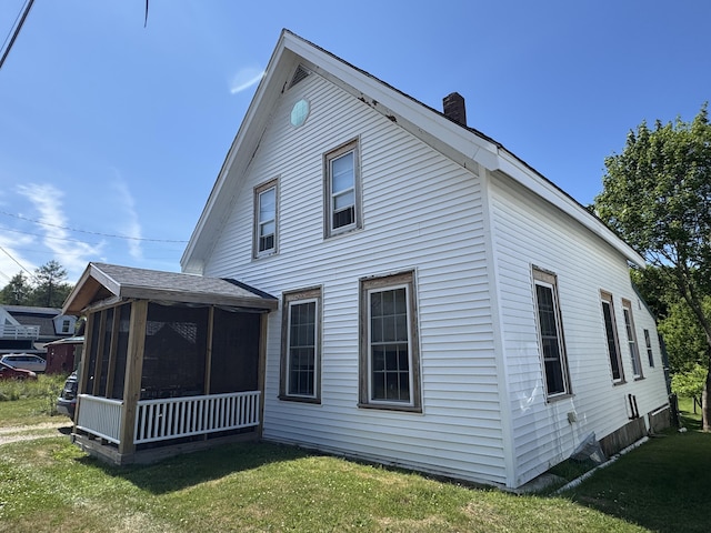 21 Wilson St, Eastport, ME 04631 - back of property featuring a sunroom, a chimney, and a yard