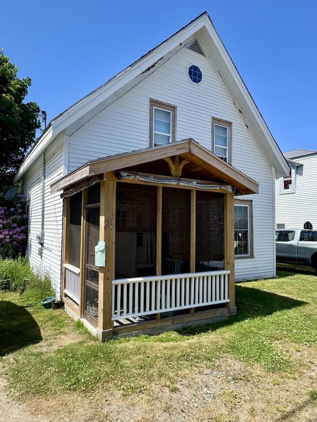 21 Wilson St, Eastport, ME 04631 - view of front of house featuring a sunroom and a front yard