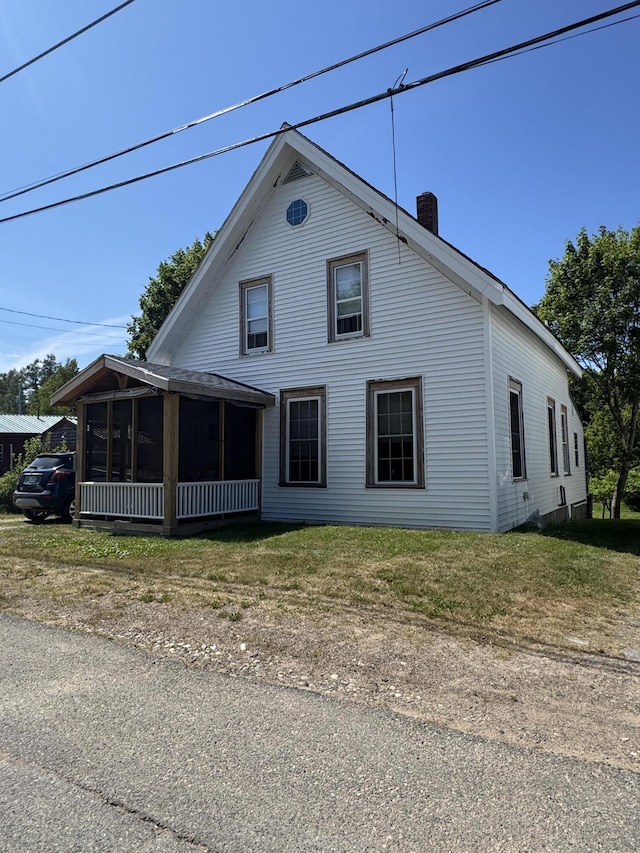 21 Wilson St, Eastport, ME 04631 - view of home's exterior with a sunroom and a chimney