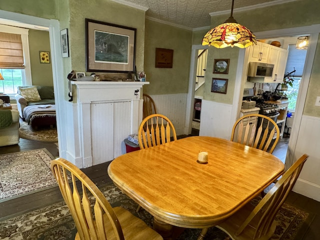 21 Wilson St, Eastport, ME 04631 - dining area featuring dark wood-type flooring, a wainscoted wall, an ornate ceiling, and crown molding